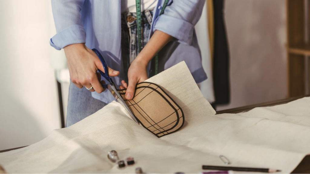 Women cutting a Cross Body Bag pattern out of fabric